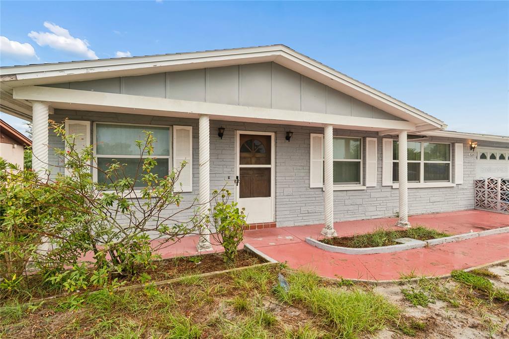 A single-story house with gray brick siding, a covered porch, and white columns — 3416 CHAUNCY ROAD, HOLIDAY, FL