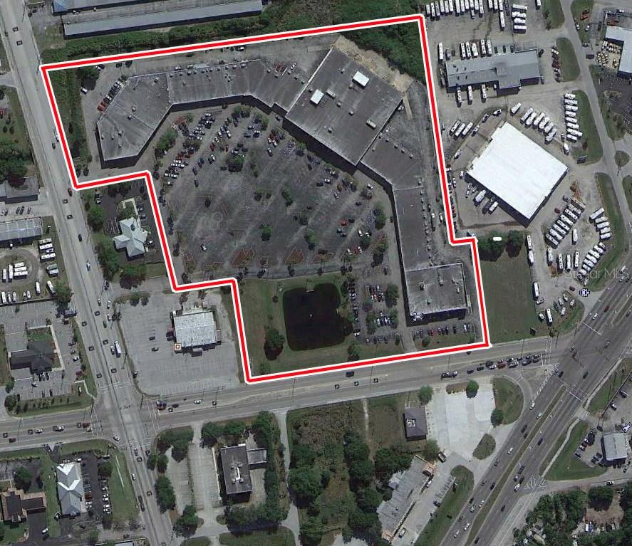 An aerial view shows a commercial building complex with a parking lot and a retention pond — 4300 KINGS HIGHWAY UNIT 409,,411,412,413,414,415, PORT CHARLOTTE, FL