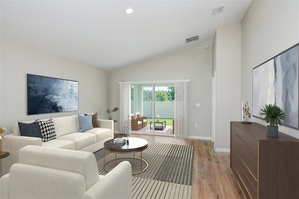 This is a digital rendering of a living room featuring a sofa, coffee table, and patio — 9136 BELLEVIEW FOREST PASS, DADE CITY, FL
