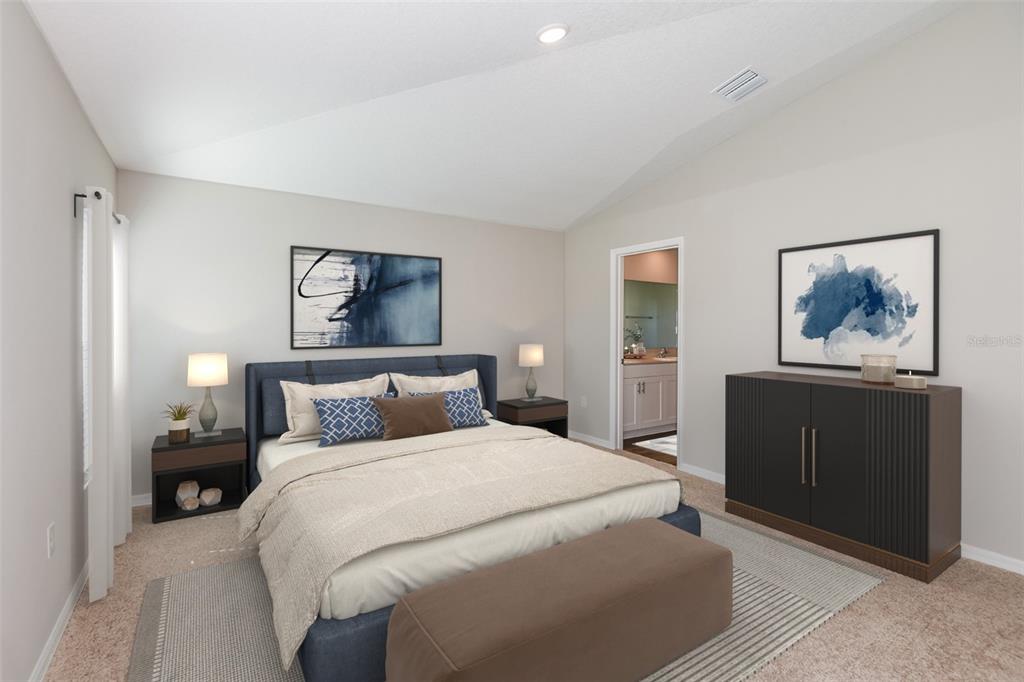 A bedroom features a blue upholstered bed, two nightstands, a dark cabinet, and wall art — 9136 BELLEVIEW FOREST PASS, DADE CITY, FL