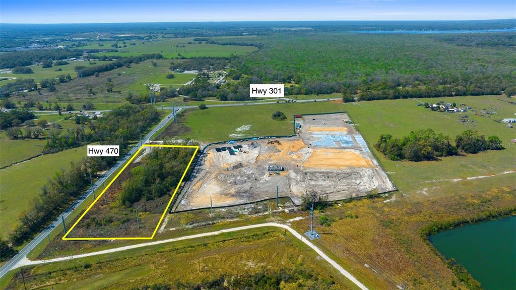 An aerial view shows a cleared construction site and an adjacent wooded lot near highways — TBD 470 HIGHWAY, SUMTERVILLE, FL