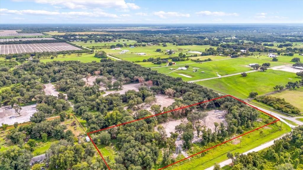 An aerial view shows a rectangular plot of land outlined in red amidst rural fields — GILL ROAD, MYAKKA CITY, FL