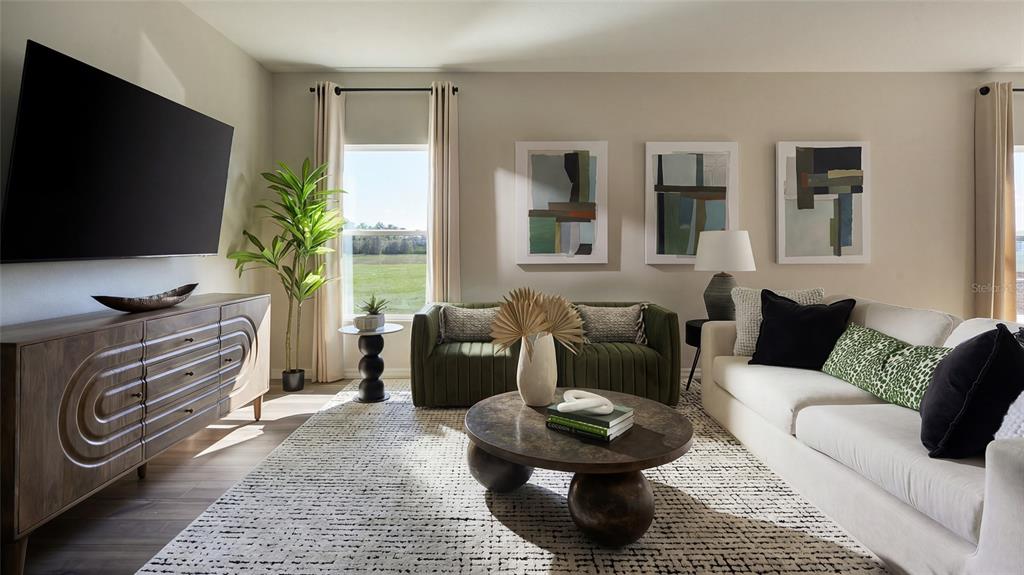 A living room features a large television, a white sofa, green chairs, and a coffee table — 9170 BENT BRANCH, DADE CITY, FL