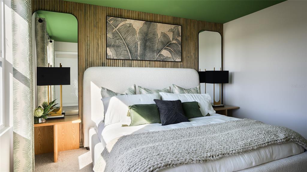 A bedroom features a white upholstered bed, wood-slat accent wall, and green ceiling — 9170 BENT BRANCH, DADE CITY, FL