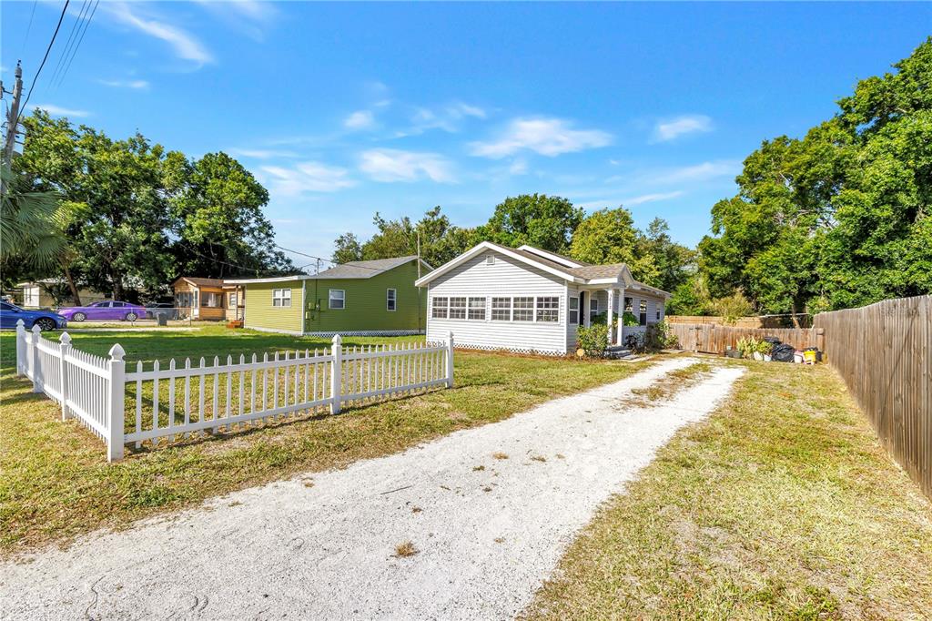 A white house and a green house sit on a lot with a gravel driveway — 3012 17TH STREET E, BRADENTON, FL