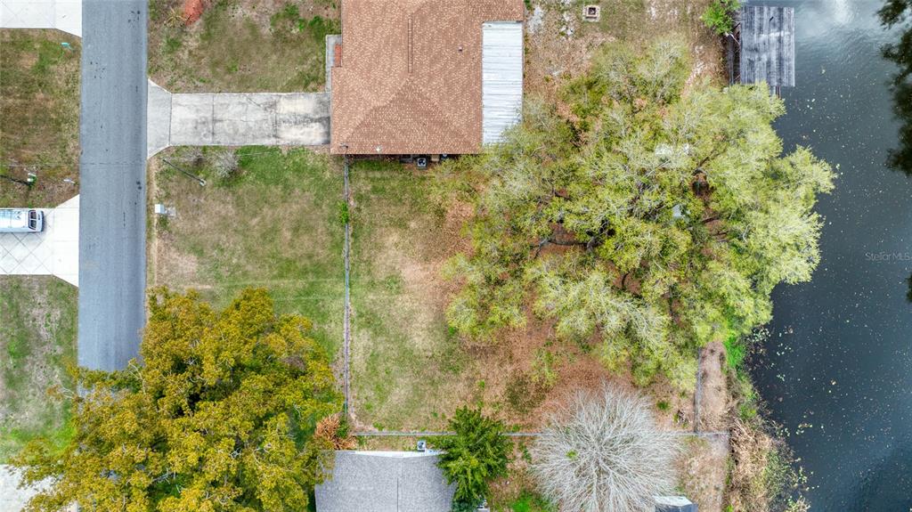 An aerial view shows a residential lot with a house, trees, and a waterfront edge — 0 LOIS DRIVE, TAVARES, FL
