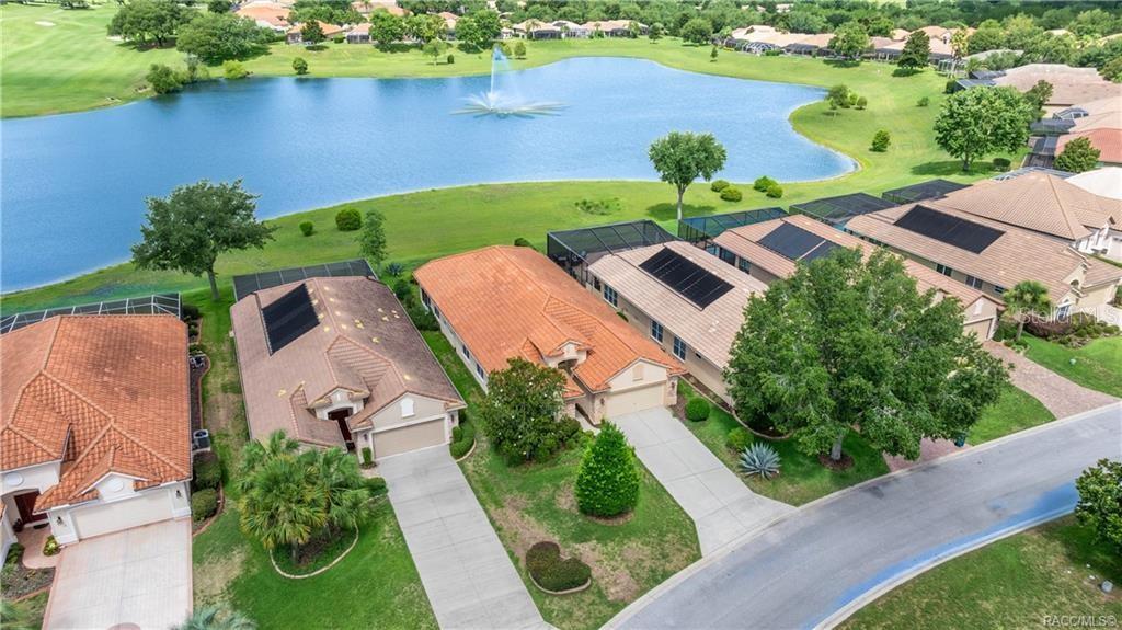 An aerial view shows several suburban houses with tile roofs situated along a large lake — 1328 W DIAMOND SHORE LOOP, HERNANDO, FL