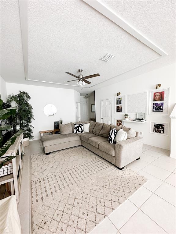 A living room features a large sectional sofa, a patterned area rug, and white walls — 966 E 10TH STREET, APOPKA, FL