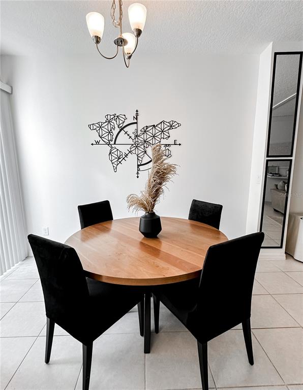 A dining area features a round wooden table, four black chairs, and a world map wall decoration — 966 E 10TH STREET, APOPKA, FL