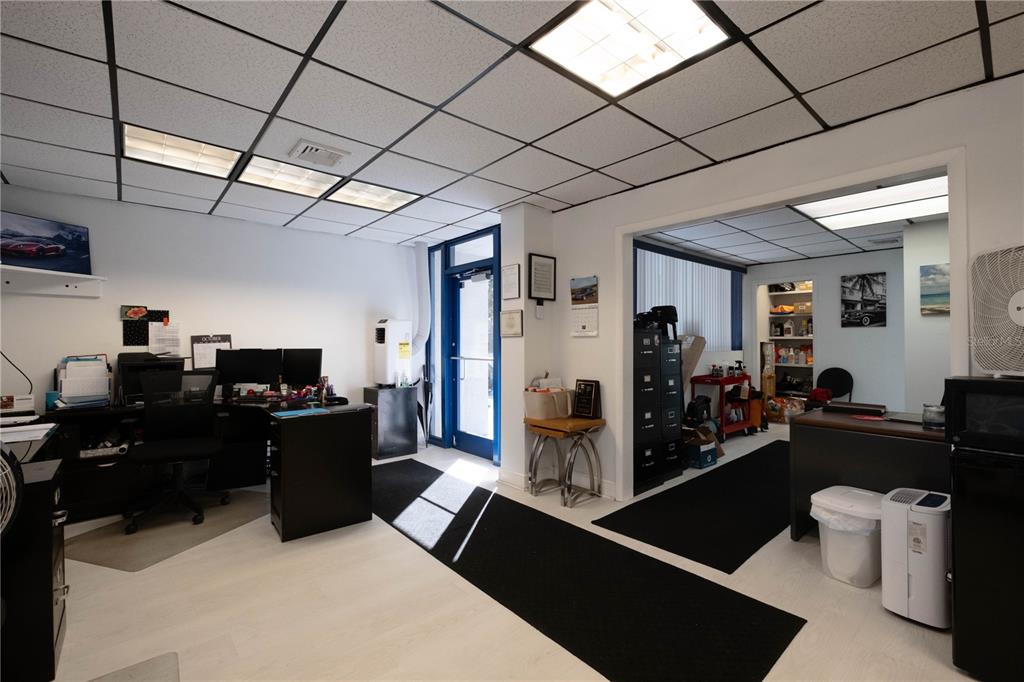 An office space features a drop ceiling, white walls, black floor mats, and two desks — 1820 NE 2ND STREET, GAINESVILLE, FL
