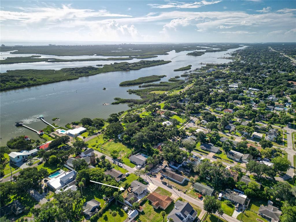 An aerial view shows a residential neighborhood with a house highlighted by a white arrow — 125 DIXWOOD AVENUE, EDGEWATER, FL