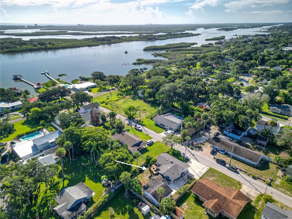 An aerial view shows a residential neighborhood with houses, trees, and a nearby waterway — 125 DIXWOOD AVENUE, EDGEWATER, FL