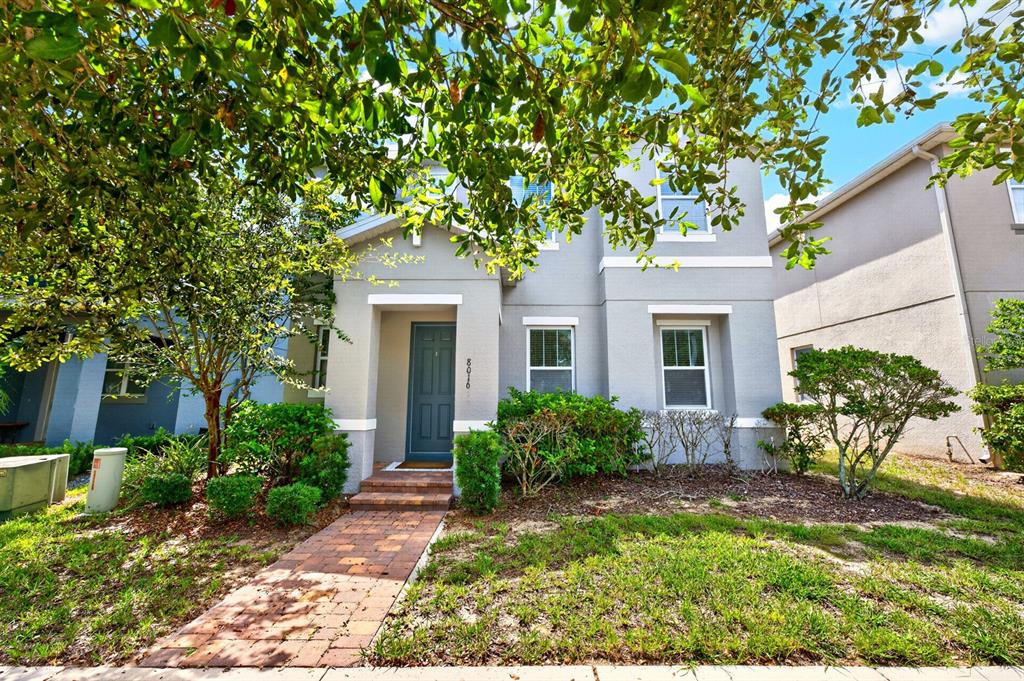 A two-story gray house with a brick walkway and a dark front door — 8016 SWEET ORANGE AVENUE, WINTER GARDEN, FL