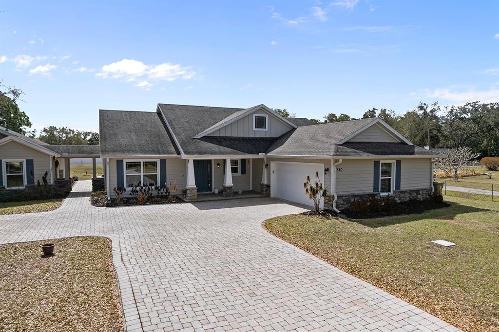 A single-story house with a paved driveway, stone accents, and a two-car garage — 4840 OLD OAK TRAIL, ST CLOUD, FL