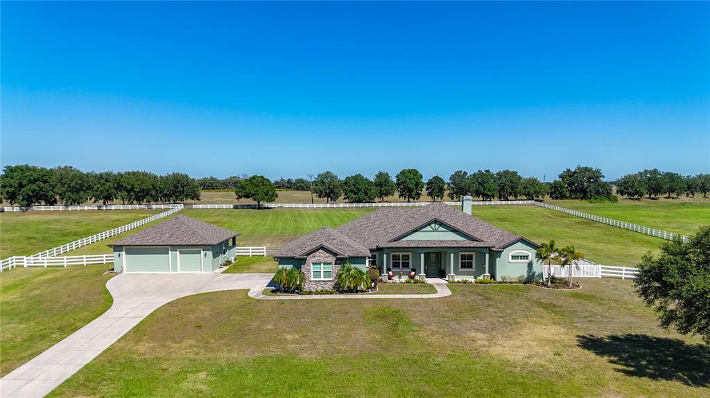 An aerial view shows a single-story house with a detached garage on a large lot — 6130 FOXBROOK TRAIL, PARRISH, FL