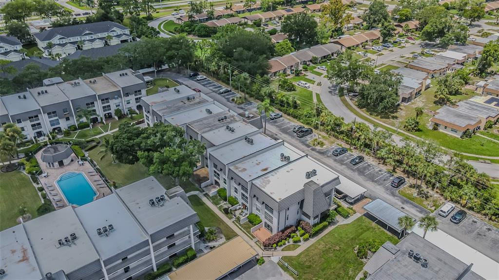 An aerial view of a multi-story apartment complex with a swimming pool and parking lot — 8765 BARDMOOR BOULEVARD UNIT 304, SEMINOLE, FL