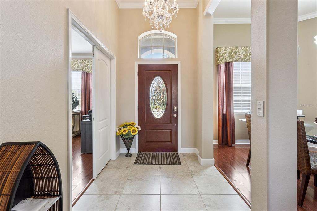 A view from a tiled hallway into a living room with hardwood floors and furniture — 2876 SANDY CAY STREET, CLERMONT, FL