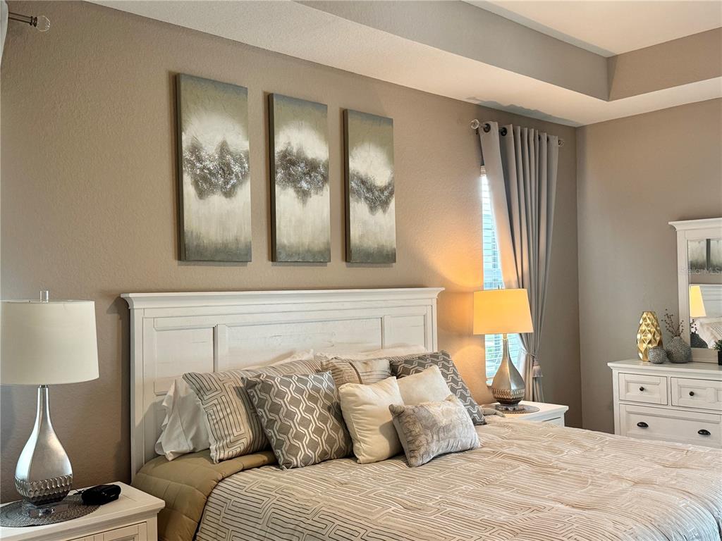 A bedroom features a white headboard, three abstract wall art pieces, and matching bedside lamps — 19146 CHERRYSTONE WAY, LAKEWOOD RANCH, FL