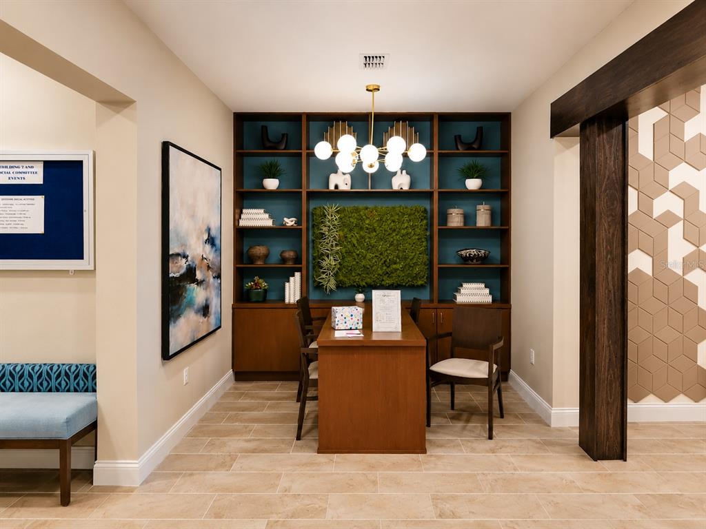A small office space features a wooden desk, built-in shelving, and a moss wall accent — 7545 LAUREATE BOULEVARD UNIT 7208, ORLANDO, FL
