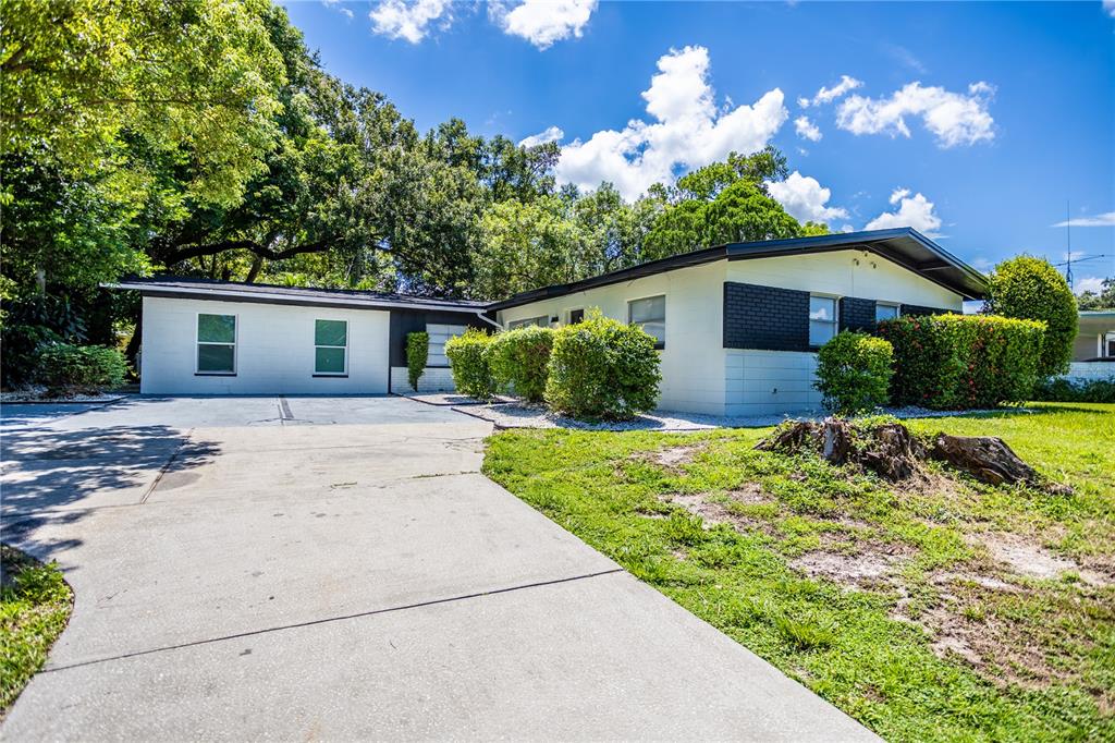 A single-story house with a white exterior, black trim, and a concrete driveway — 1213 CORBETT LANE, ORLANDO, FL