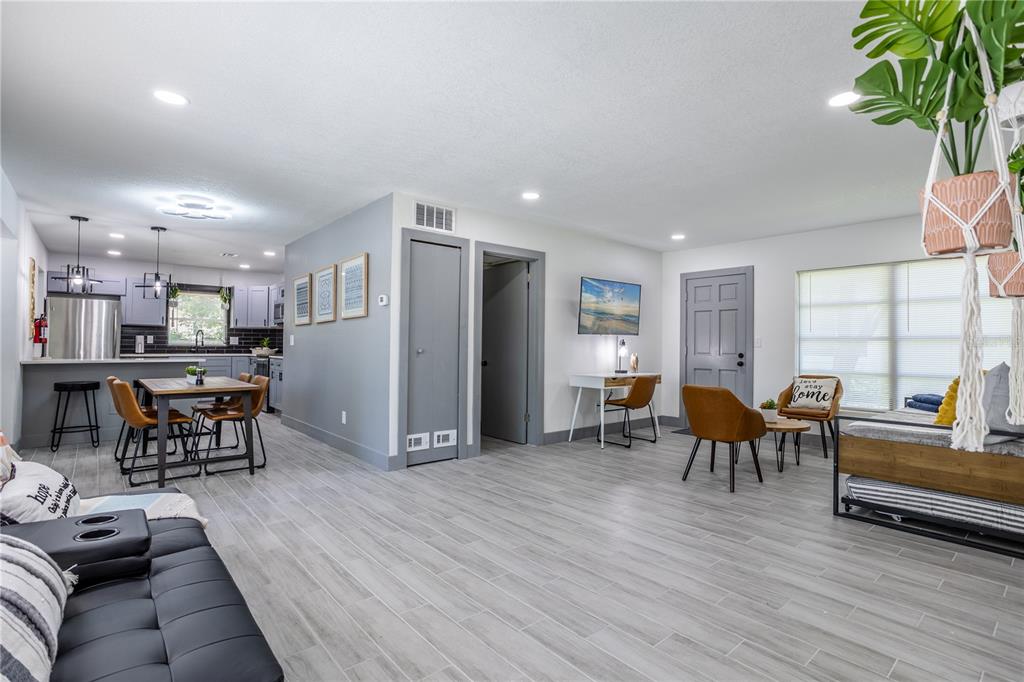 An open-concept living room and kitchen feature light gray tile flooring and gray trim — 1213 CORBETT LANE, ORLANDO, FL