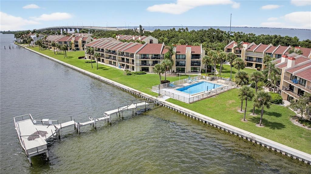 An aerial view of a waterfront condominium complex with a swimming pool and a pier — 7550 SUNSHINE SKYWAY LANE S UNIT P12, ST PETERSBURG, FL
