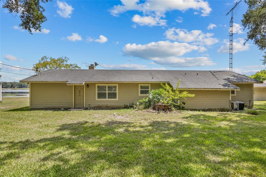 A single-story house with tan siding and a gray shingled roof sits on a lawn — 6417 BAKER ROAD, KEYSTONE HEIGHTS, FL
