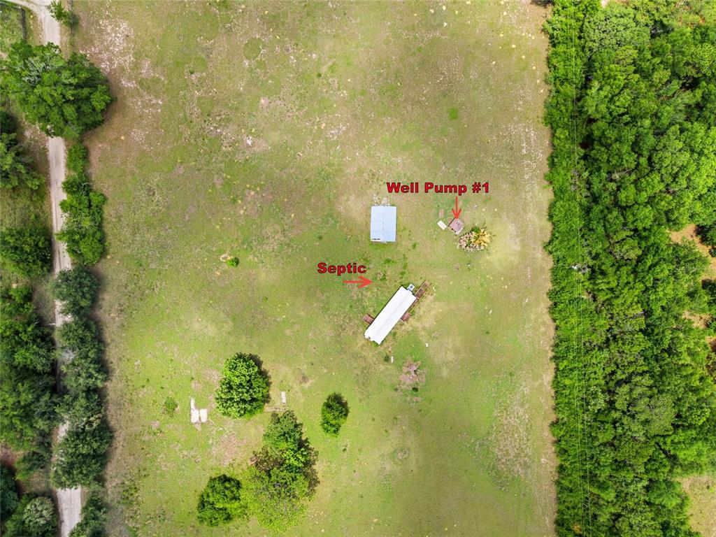 This aerial view shows a grassy lot with two small buildings, a well, and septic — 12630 U.S. 441, BELLEVIEW, FL