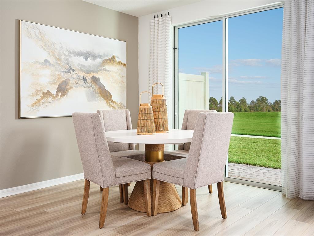 A dining area features a round white table, four upholstered chairs, and a sliding glass door — 16266 BIRD OF PARADISE AVENUE, CLERMONT, FL
