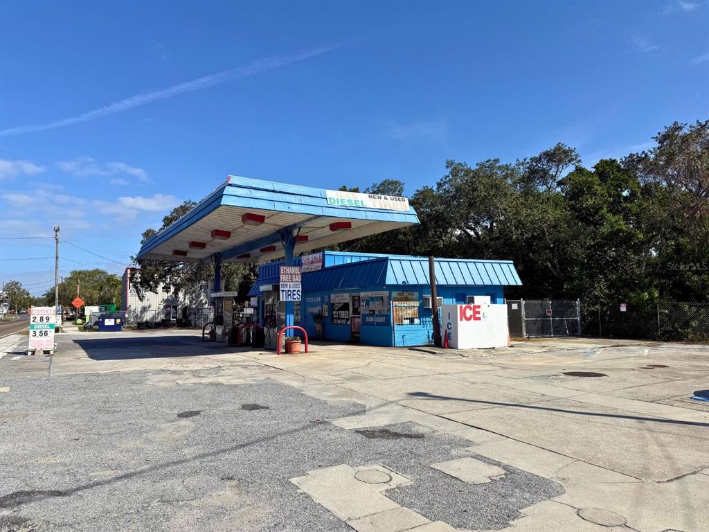 A small, blue gas station with a canopy and a paved lot under a clear sky — 1941 S PINELLAS AVENUE, TARPON SPRINGS, FL