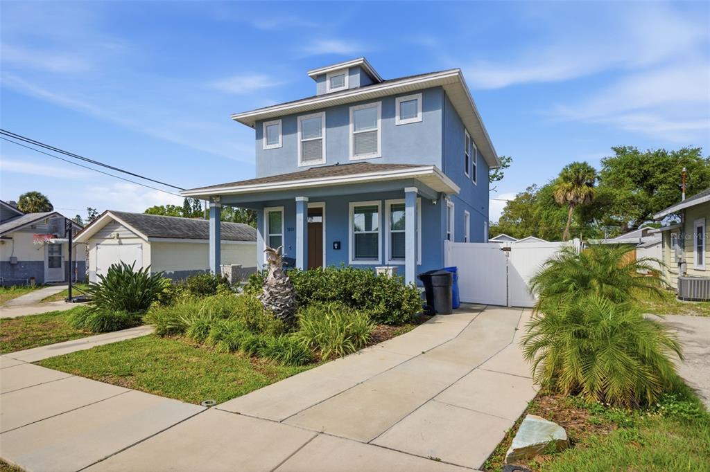 A two-story blue house with a front porch, a concrete driveway, and a detached garage — 3222 PRESCOTT STREET N, ST PETERSBURG, FL