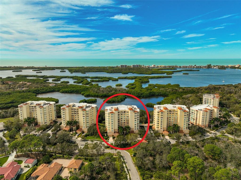An aerial view shows a multi-story residential building circled in red among coastal mangroves — 401 N POINT ROAD UNIT 1001, OSPREY, FL