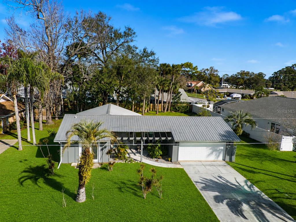 An aerial view of a single-story house with a metal roof and a large lawn — 101 SEA STREET, NEW SMYRNA BEACH, FL