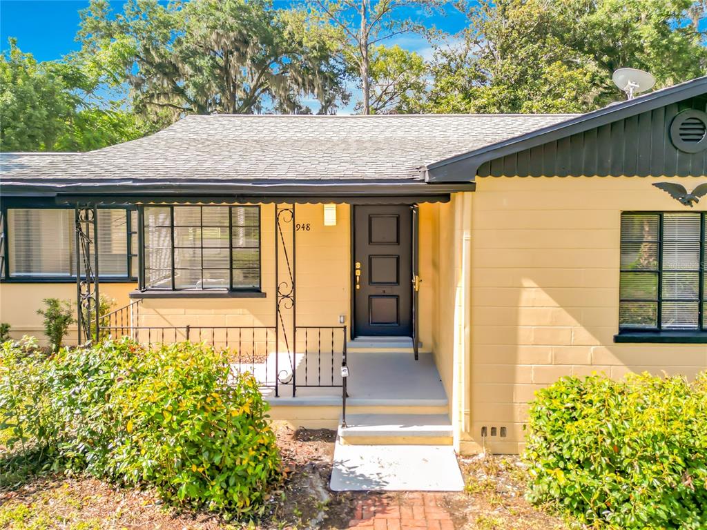 A single-story house with yellow block walls, a dark front door, and black trim — 948 NE 6TH ST, OCALA, FL