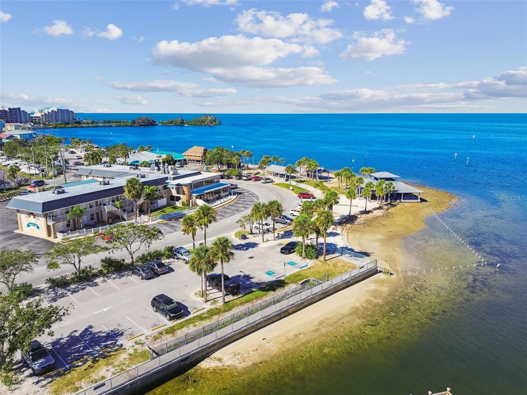 An aerial view shows a waterfront hotel with a parking lot and a sandy beach — 12617 4TH ISLE, HUDSON, FL