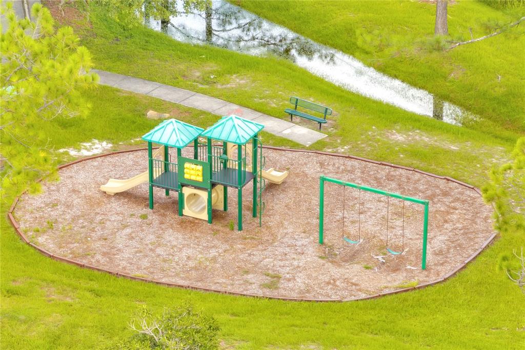 An aerial view of a playground with a climbing structure, swings, and a bench nearby — 3030 HOLLAND DRIVE, ORLANDO, FL