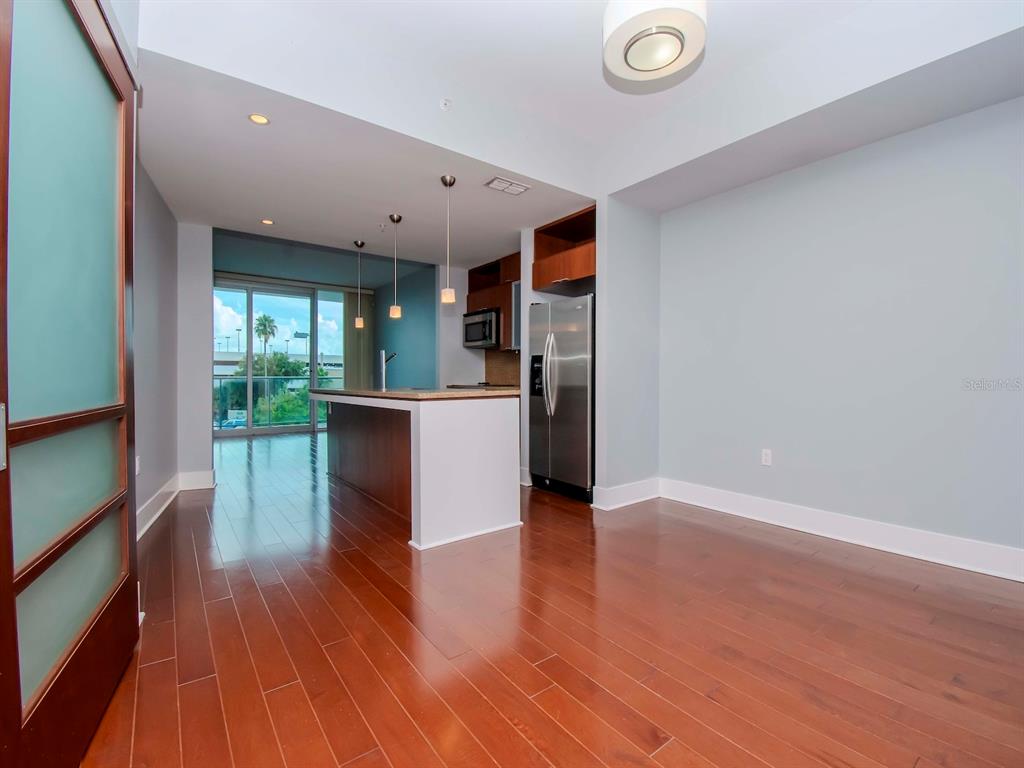A modern kitchen with stainless steel appliances and a center island overlooks a balcony — 912 CHANNELSIDE DRIVE UNIT 2311, TAMPA, FL