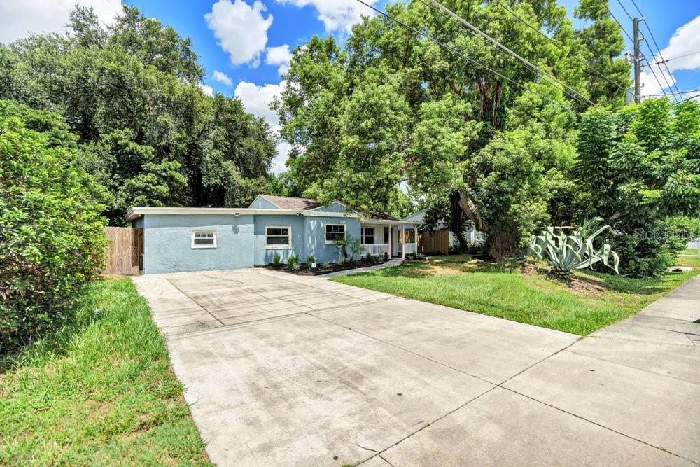 A light blue single-story house features a concrete driveway and mature trees in the yard — 2829 LAKE MARGARET DRIVE, ORLANDO, FL