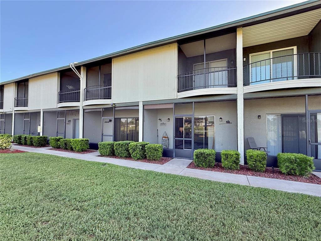A two-story apartment building features screened-in patios on the ground floor and balconies above — 3635 EDGEWATER DRIVE UNIT 3635, SEBRING, FL