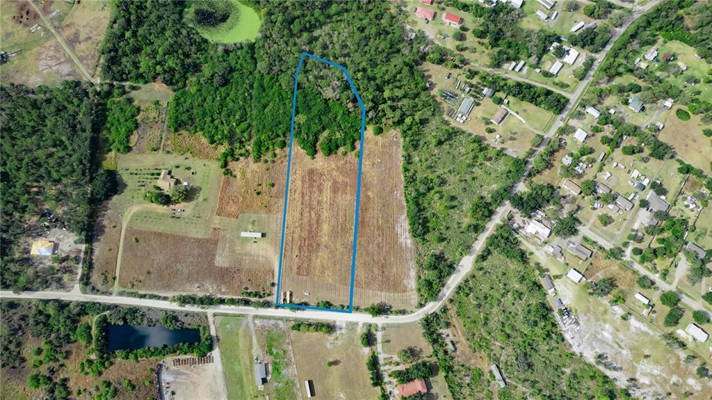 An aerial view shows a rectangular plot of land outlined in blue amidst rural surroundings — 14451 SEMINOLE TRAIL, WIMAUMA, FL