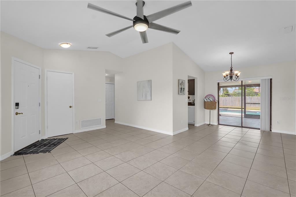An open-concept living and dining area features tile flooring, a ceiling fan, and sliding doors — 5165 FORMBY DRIVE, ORLANDO, FL
