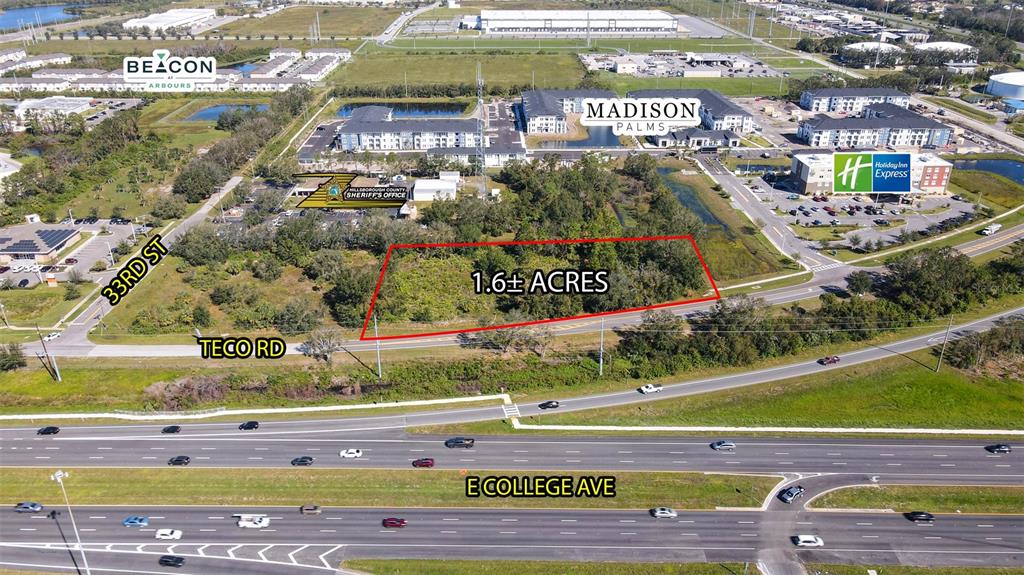 This aerial view shows a vacant 1.6-acre lot outlined in red near a highway — TECO ROAD, RUSKIN, FL