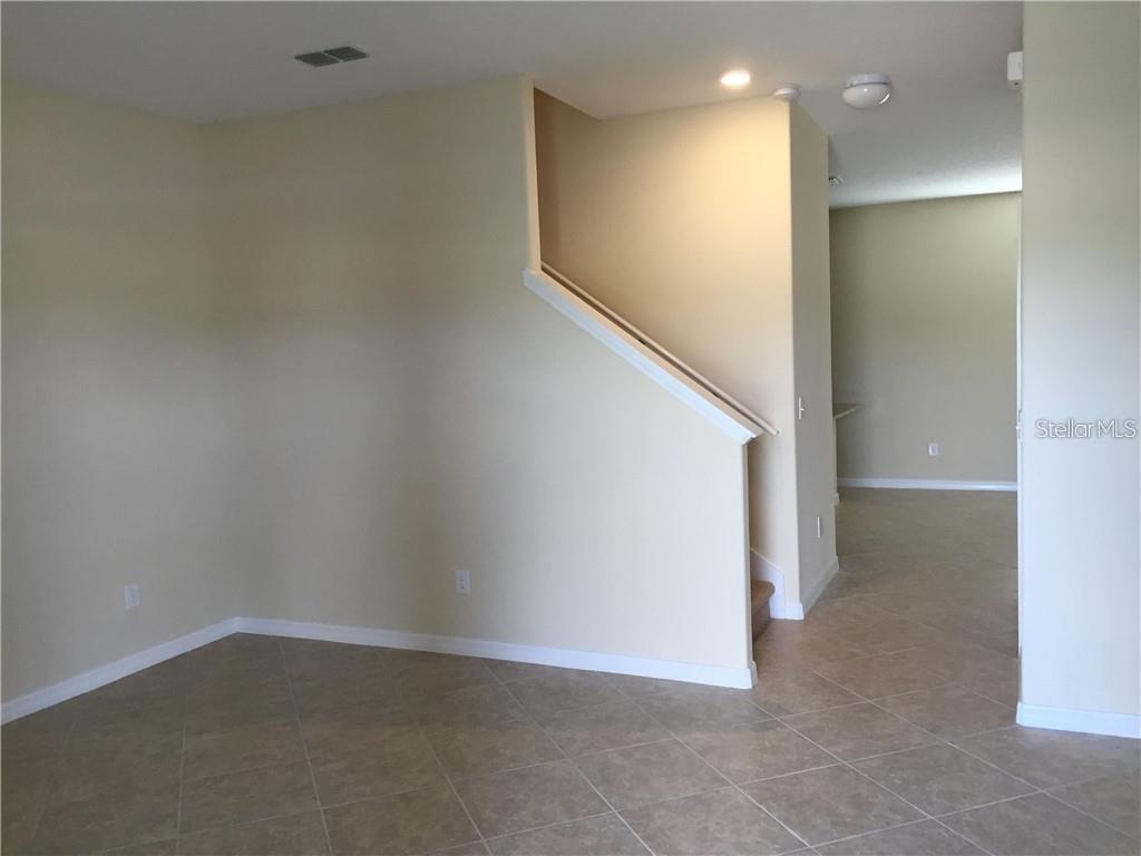 An interior view showing a tiled floor, a staircase with a railing, and beige walls — 13048 GARRIDAN AVENUE, WINDERMERE, FL