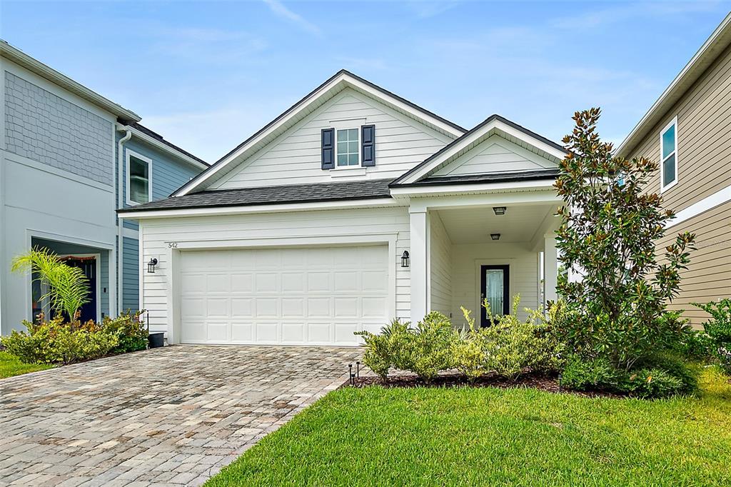 A white house with a two-car garage, a covered entryway, and a paved driveway — 542 SILVER LANDING DRIVE, ST AUGUSTINE, FL