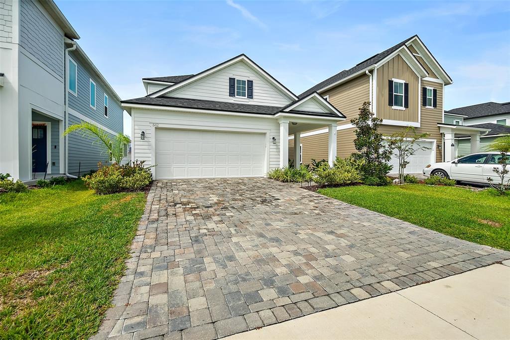 A single-story house with a white garage and a paved driveway sits between two homes — 542 SILVER LANDING DRIVE, ST AUGUSTINE, FL