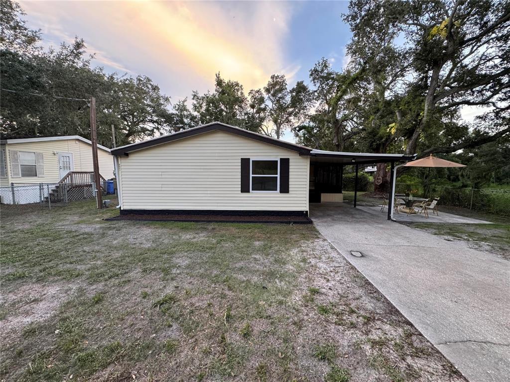 A single-story house with light siding, a carport, and a concrete driveway — 8801 MARC DAVID, GIBSONTON, FL