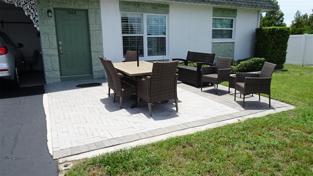 A swimming pool with lounge chairs sits on a patio next to a white building — 7868 40TH AVENUE N UNIT 7868, ST PETERSBURG, FL