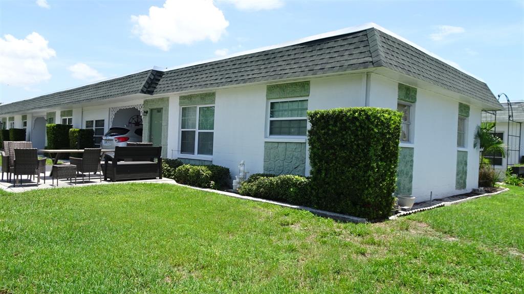 A living room with a light blue sofa and a dining area in the background — 7868 40TH AVENUE N UNIT 7868, ST PETERSBURG, FL