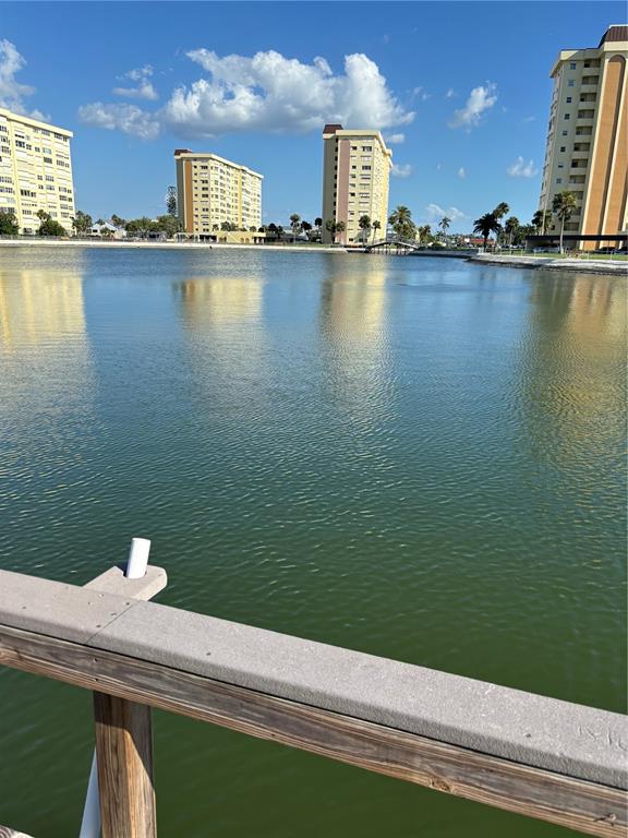 A view of a lake with several high-rise apartment buildings in the background — 4725 COVE CIRCLE UNIT 104, MADEIRA BEACH, FL