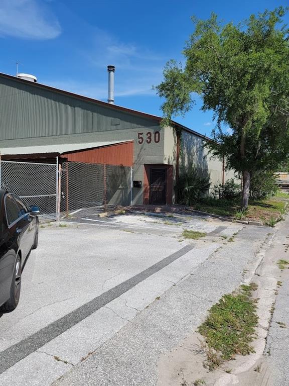 An exterior view of a commercial building with a metal roof and a chain-link fence — 530 NW 1ST AVENUE, OCALA, FL